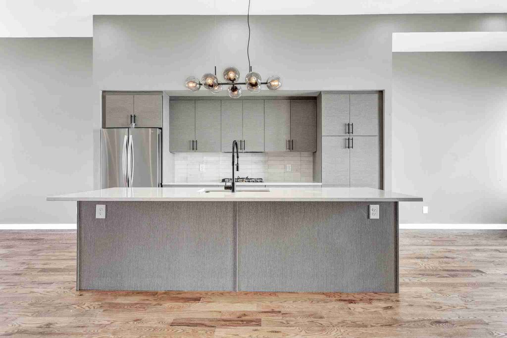 Contemporary Atlanta home kitchen with island, modern light fixture, and stainless steel appliances
