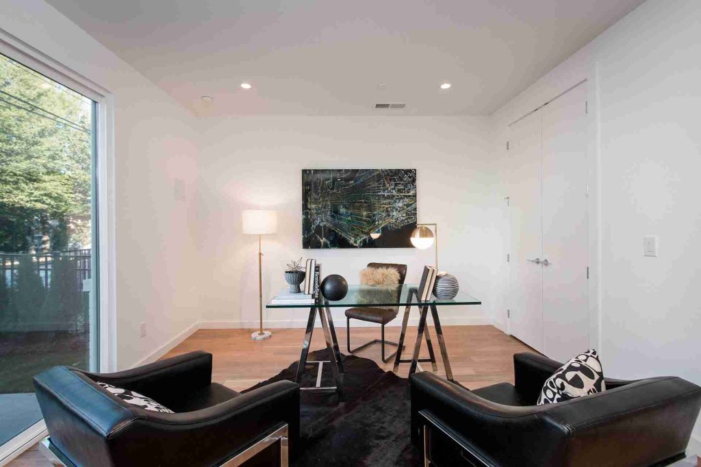 Home with glass desk, leather chairs, art, and window views